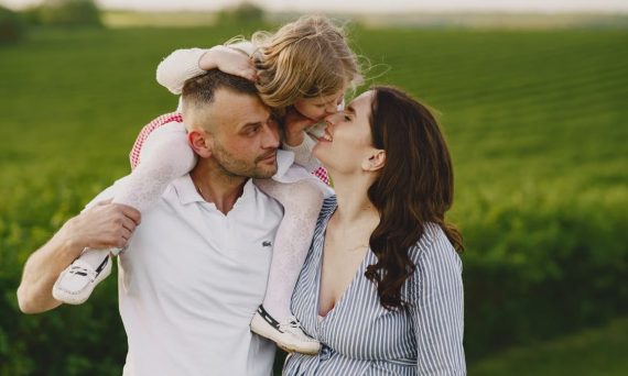 A delightful family moment captured in a lush scenic field, portraying love and happiness.